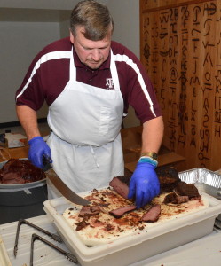 Ray Riley, manager of the Rosenthal Meat Science and Technology Center at Texas A&M University, slices beef tenderloin to serve attendees at the recent barbecue town hall meeting. (Texas A&M AgriLife Extension Service photo by Blair Fannin)