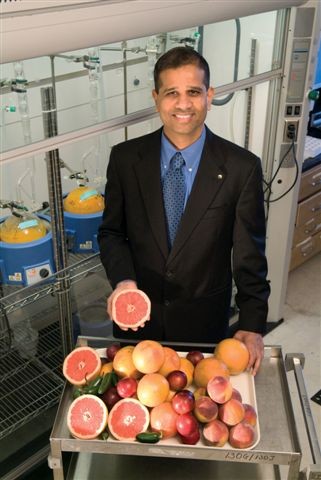 A man, Bhimu Patil, standing behind an assorted citrus display