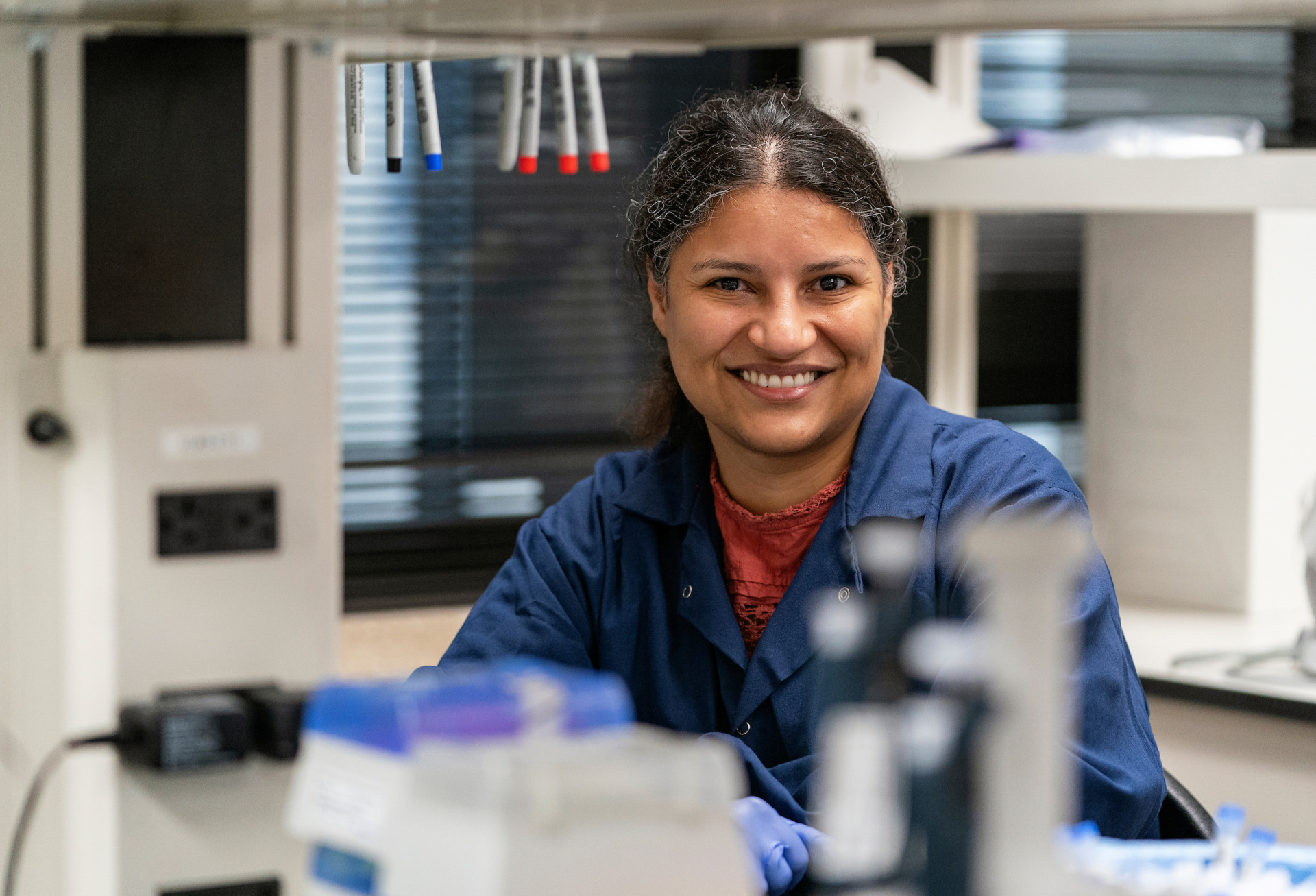 A smiling woman in a lab setting
