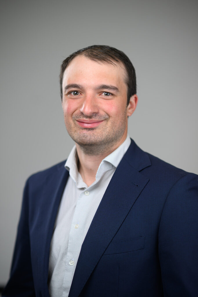 Head and shoulder photo of Garrett Slater, Ph.D. He is wearing a dark blue coat with a light blue shirt.