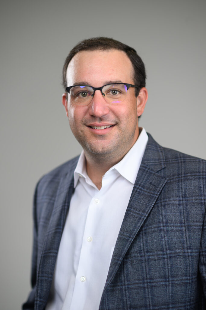 a man in glasses in a nice jacket - Sam Rustom