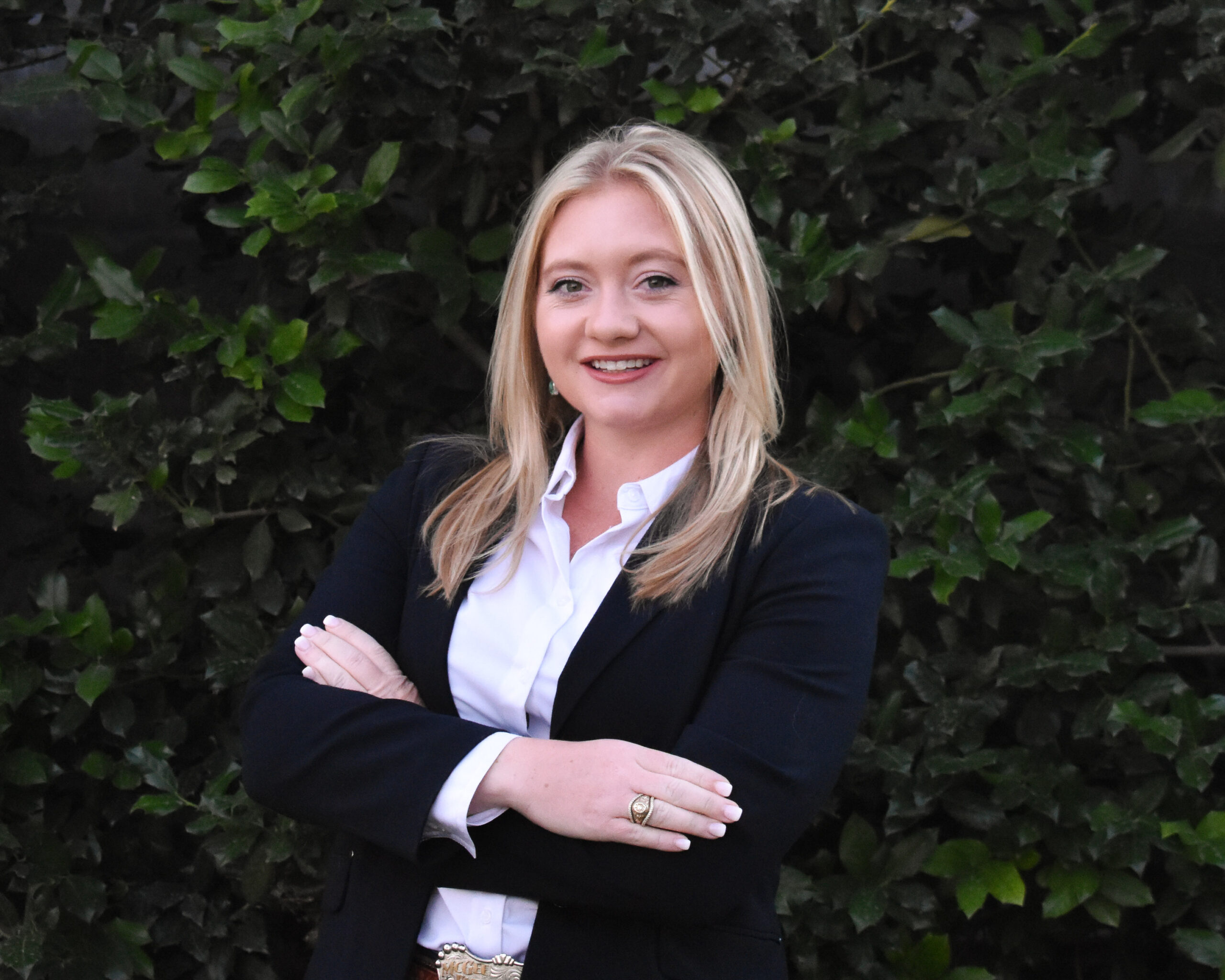 A woman, Sarah McEntire Prather, stands outdoors with her hands folded