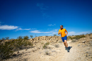 A runner sprints through a desert trail