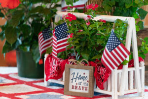 Table decor with American flags and a small wooden sign reading “Home of the Brave”