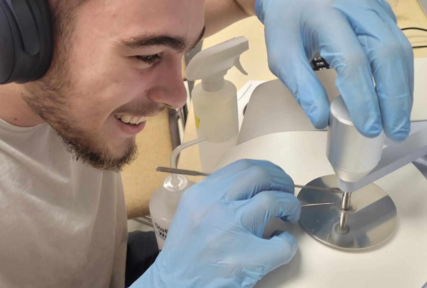 A researcher in the Kurouski lab smiling while using the spectroscopy tool to analyze a small insect