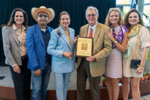 Members of the T.V. Munson family receive a plaque from Dr. Amit Dhingra (wearing a straw hat).