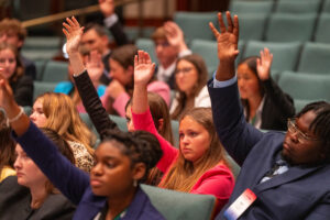 A group of 4-H students raising their hands during the 4-H Congress