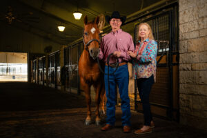 Tom and Donna Bigbee pose next to a horse.